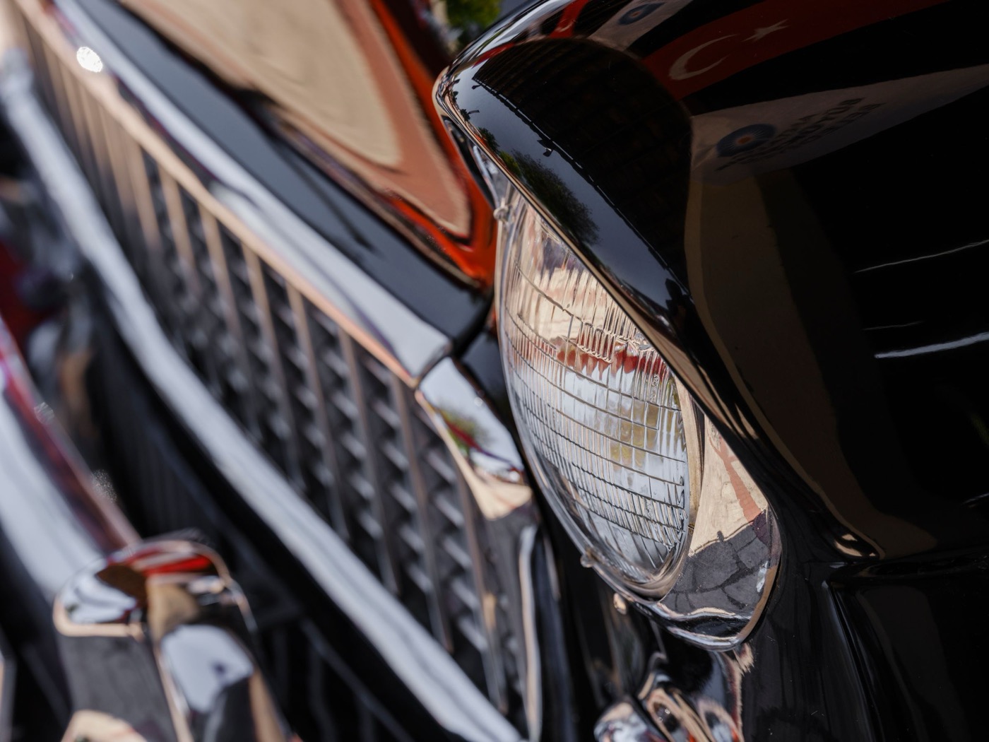Warm reflections running clean across polished chrome trim and a headlight surround